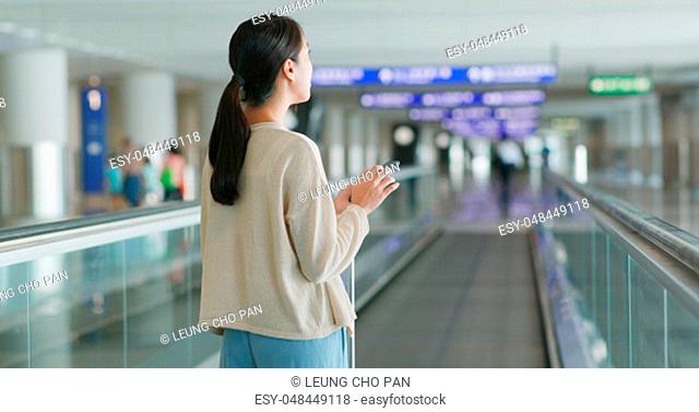 Woman checking flight number on cellphone in the airport
