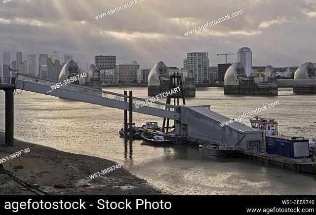 Views of river Thames barrier and Canary Wharf from Woolwich docks, London, England, UK