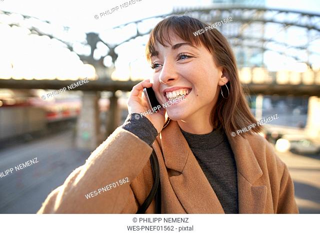 Portrait of happy young businesswoman on the phone outdoors