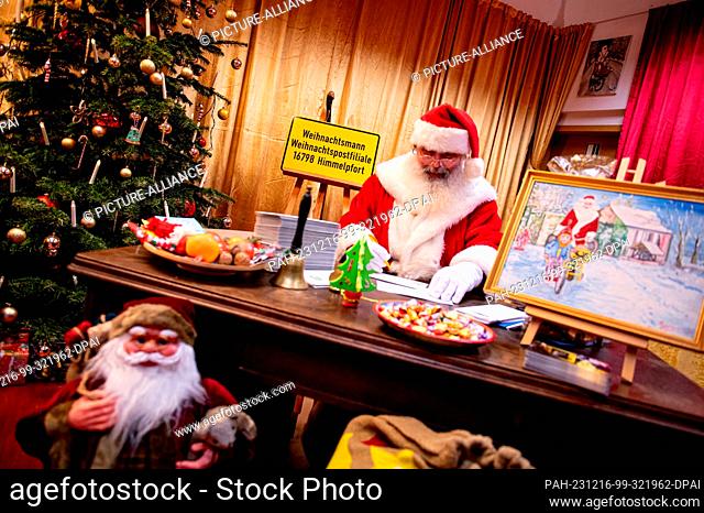 16 December 2023, Brandenburg, Himmelpfort: Santa Claus sits in the Christmas post office in northern Brandenburg and answers letters from children