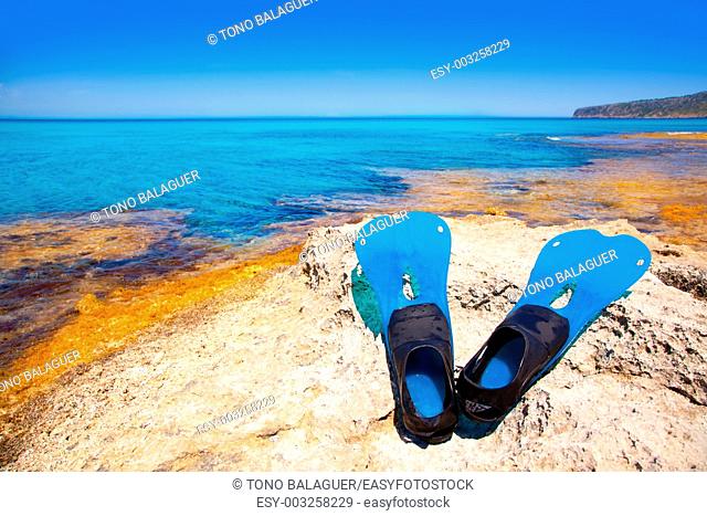 Balearic Formentera island with scuba diving blue fins on a rock