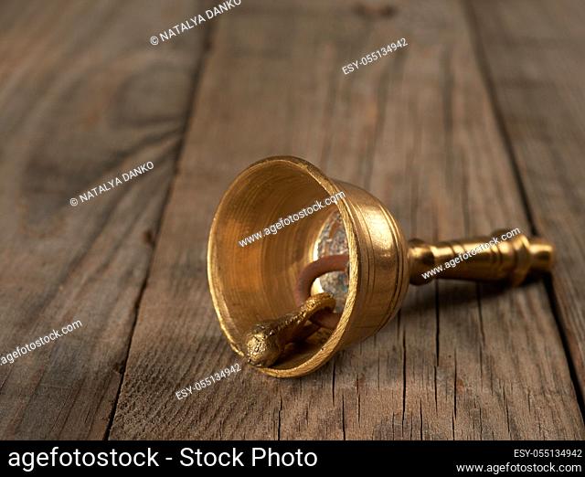 bronze bell for alternative medicine on a wooden background, meditation and relaxation