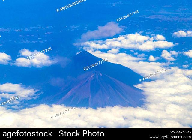 Flying by plane over Mexico with view of volcanoes mountains and clouds