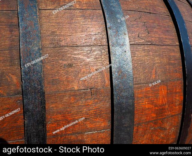 A traditional old wooden barrel with curved walls and metal hoops. Dishes for the ripening of alcoholic beverages - mead, beer, wine, whiskey