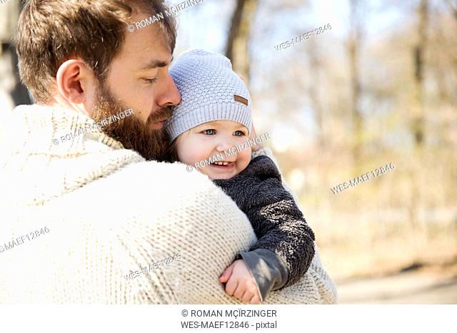 Affectionate father carrying daughter in park