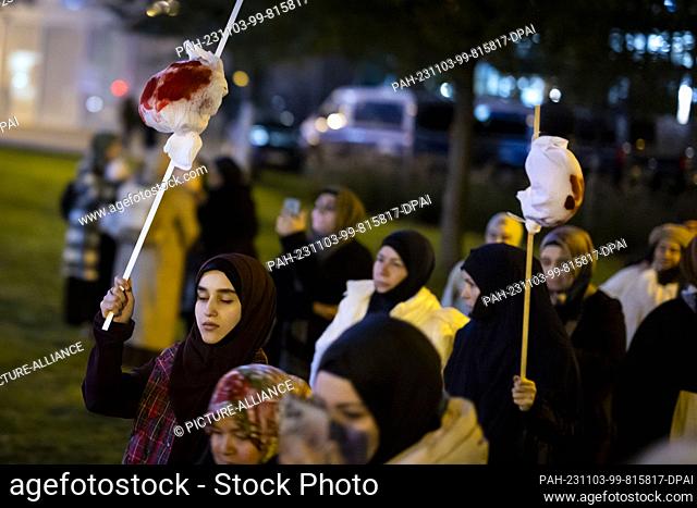 03 November 2023, North Rhine-Westphalia, Essen: Women carry small bundles of fake blood to symbolize dead children in Gaza at the rally ""Gaza under attack -...