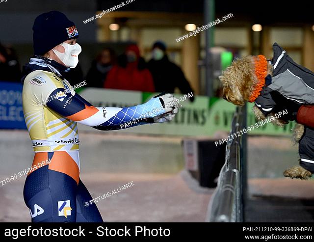 10 December 2021, North Rhine-Westphalia, Winterberg: Skeleton: World Cup, women, 2nd run. Kimberley Bos from the Netherlands cheers with her dog about her...