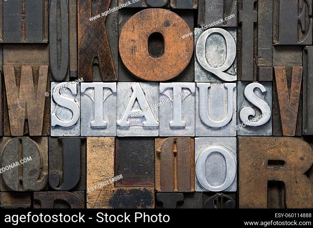 status quo cross words made from metallic letterpress blocks in mixed wooden letters