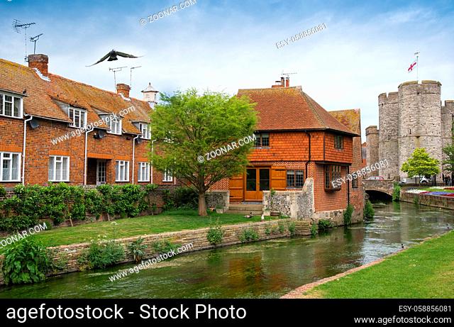 Canterbury, United Kingdom - May 15 2017: Cityscape of Canterbury, Kent UK with the West Gate tower and canal of river Stour passing near the houses