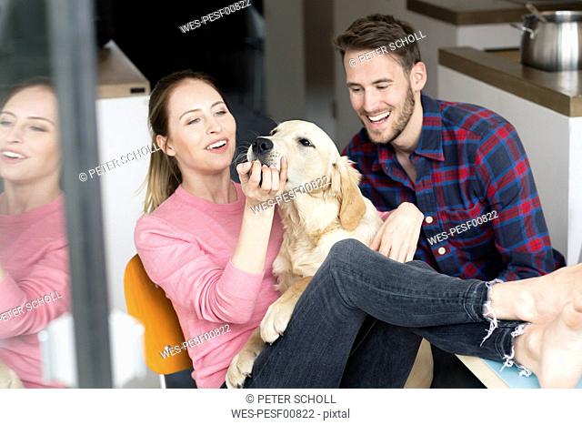 Happy young couple with dog at home
