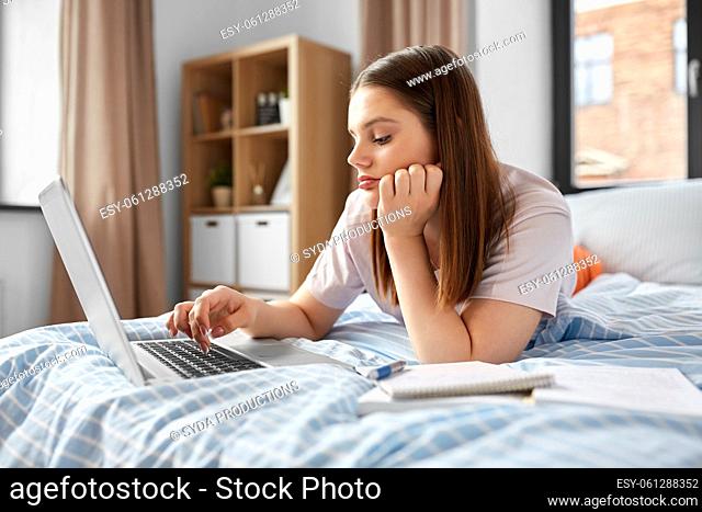 teenage student girl with laptop learning at home