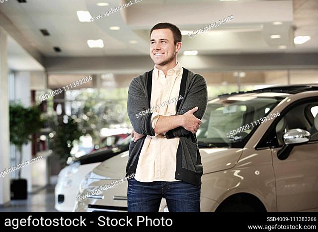Caucasian man standing in car showroom