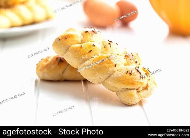 Tasty braided buns on white table