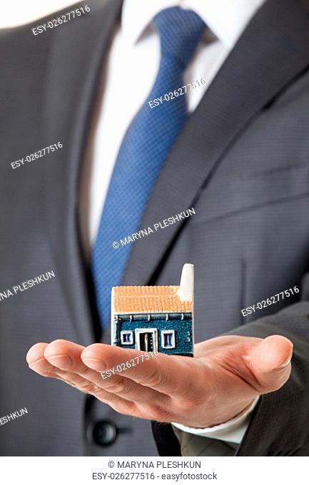 Unrecognizable businessman holding a toy house on his palm
