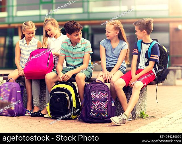 group of happy elementary school students talking