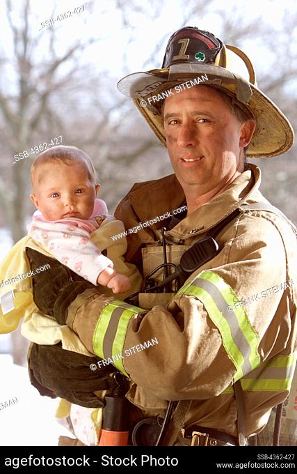 Firefighter Holds Baby at the Scene of a Fire