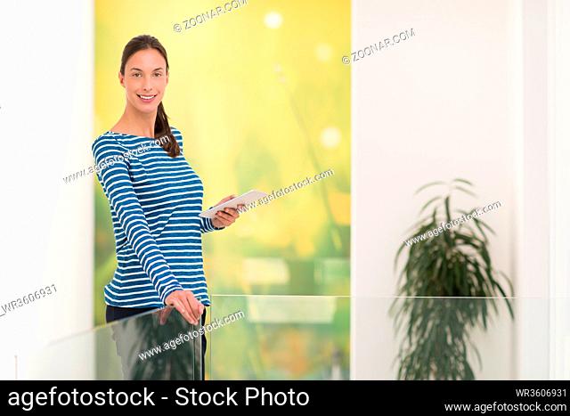 beautiful young woman at home websurfing on internet with tablet