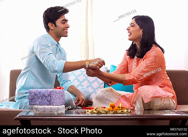 A YOUNG WOMAN HAPPILY CELEBRATING RAKSHABANDHAN WITH BROTHER