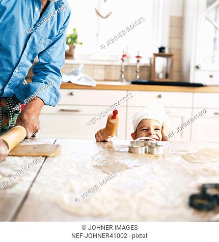 Smiling boy baking with his father