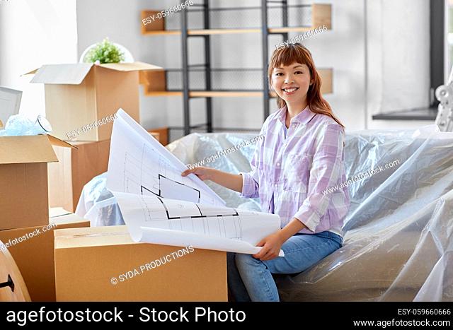 woman with blueprint and boxes moving to new home