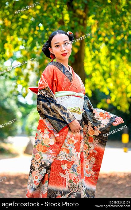 Portrait of smiling woman wearing kimono in park