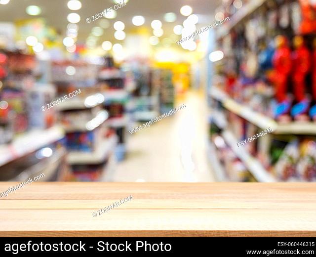 Wooden board empty table in front of blurred background. Perspective light wood over blur in kids toys store - can be used for display or montage your products