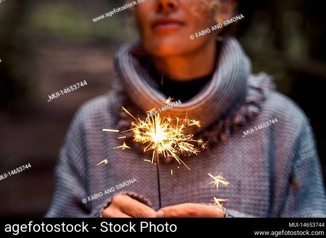 Close up of woman people holding sparkler and celebrate outdoor. New year eve and christmas celebration concept. Happiness and serene female person