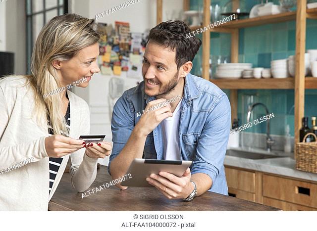 Couple using digital tablet to shop online at home