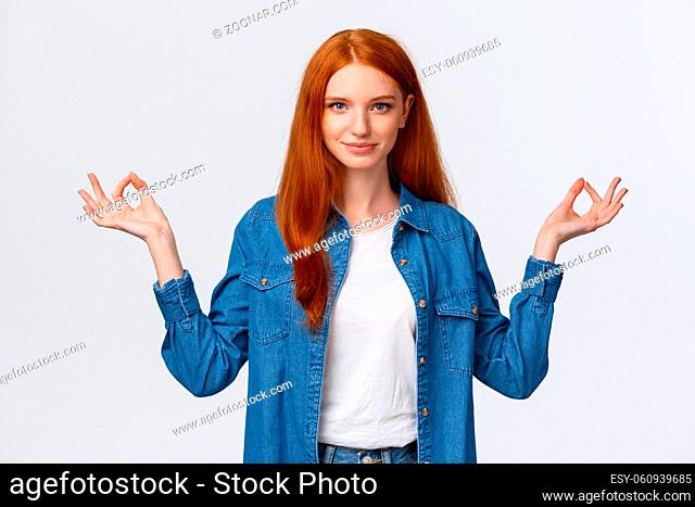 Waist-up portrait confident and relieved, patient good-looking redhead woman calm down daily yoga practice with app, hold hands sideways zen gesture in lotus...