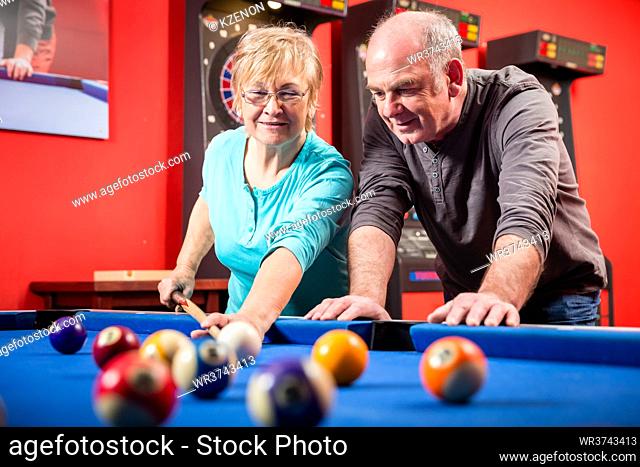 Portrait of a smiling mature couple playing billiard