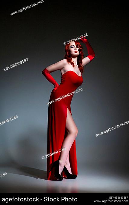 Beautiful young Woman with red hair dressed in red elegant dress