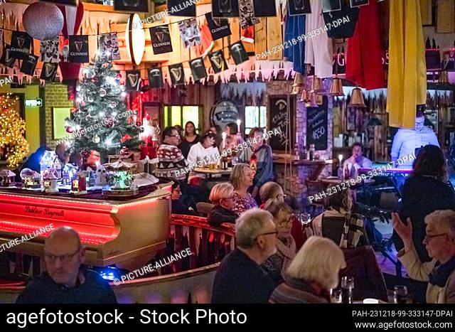 PRODUCTION - 17 December 2023, Bavaria, Bayreuth: Guests in the Irish pub take part in the service. Under the name ""Sunday Evening Church""