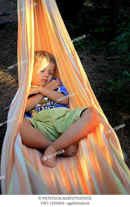 Boy aged 4 resting in a hammock
