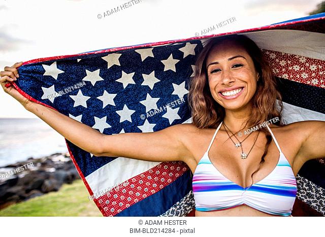 Woman standing under American flag quilt