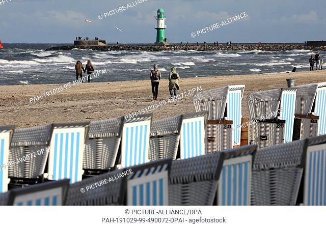 28 October 2019, Mecklenburg-Western Pomerania, Rostock: The beach chairs of the ""Strandkorbvermietung Warnemünde Fritz"" are located at the Baltic Sea beach...