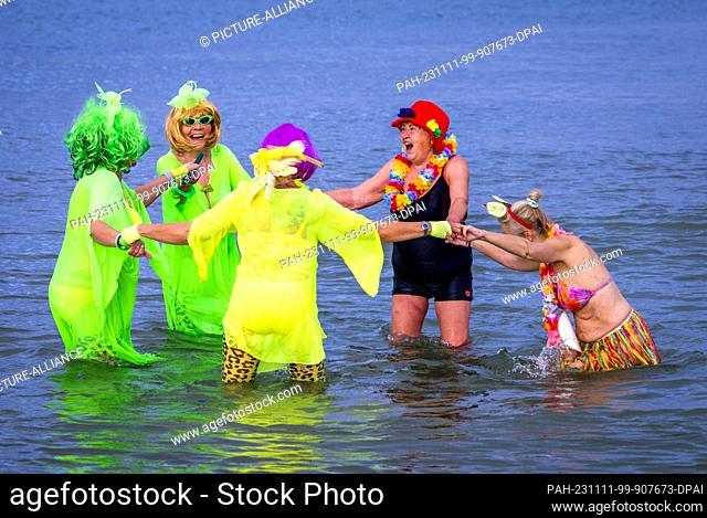 11 November 2023, Mecklenburg-Western Pomerania, Rostock: Members of the Rostocker Seehunde ice swimming club kick off the carnival season with colorful...