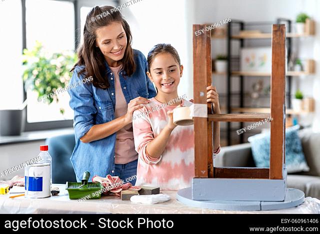 mother and daughter sticking masking tape to table