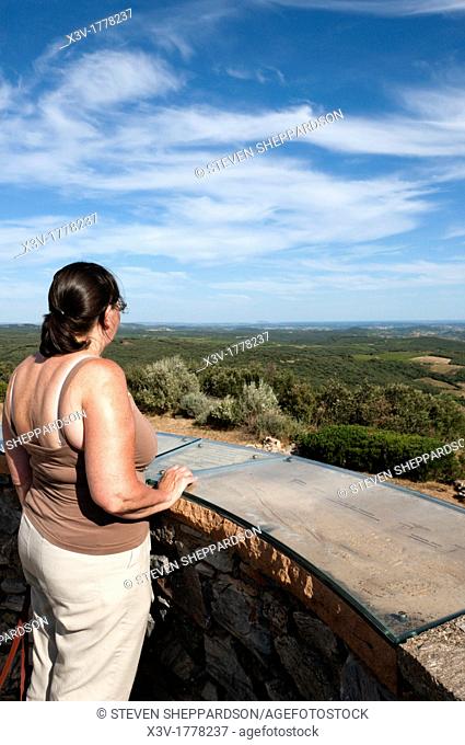 Europe, France, Languedoc-Roussillon - a tourist looks out from a viewing platform on an old windmill in the Haut Languedoc National Park near Faugeres