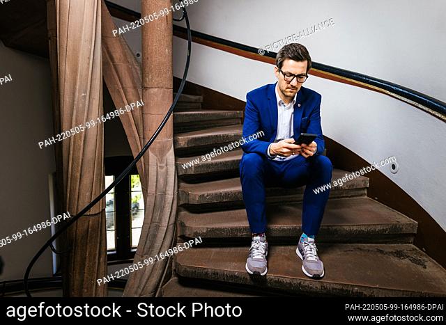 27 April 2022, Baden-Wuerttemberg, Freiburg: Martin Horn (independent), mayor of Freiburg, sits on the steps of a spiral staircase in the city's town hall