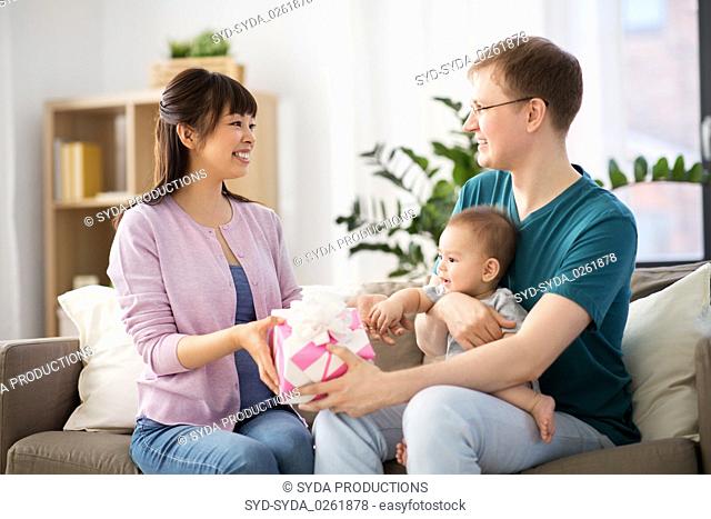 happy family with gift and baby boy at home