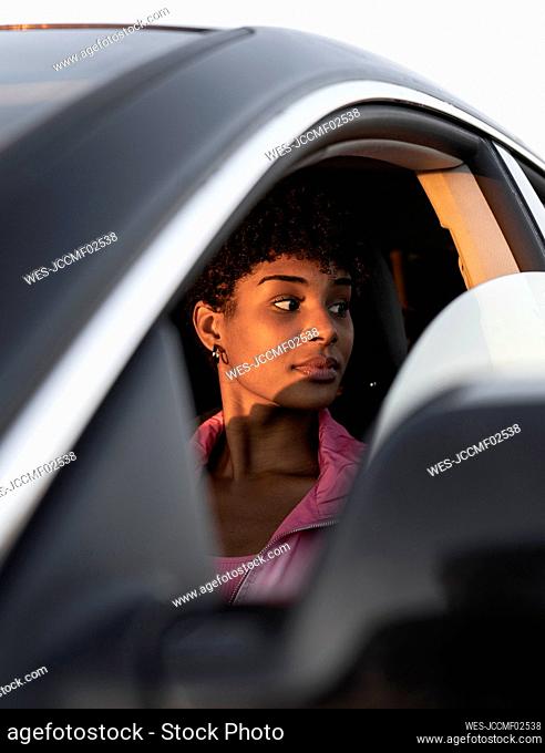 Contemplating woman looking away from window in car