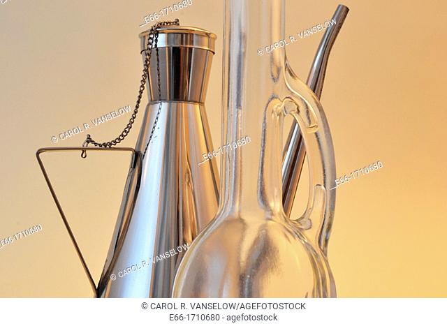 two olive oil bottles: one glass with long neck, one stainless steel