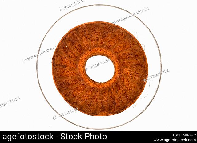 Circular marbled cake laying on a glass tray top view on a white background