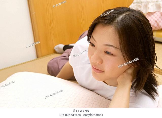 Leisure of Asian woman lie on ground of room in home