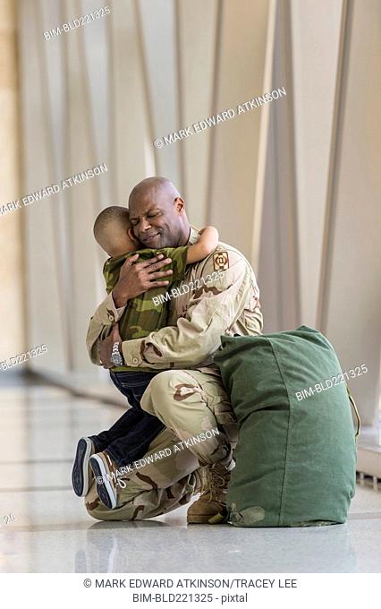 African American soldier hugging son in airport