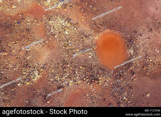 Little pool and extremely mineral-rich ground in the area of the Rio Tinto mines, the colour is caused by oxidised iron minerals, aerial view, drone shot