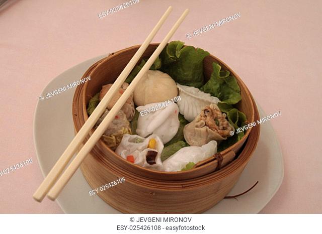 wontons in wooden bowl with sticks