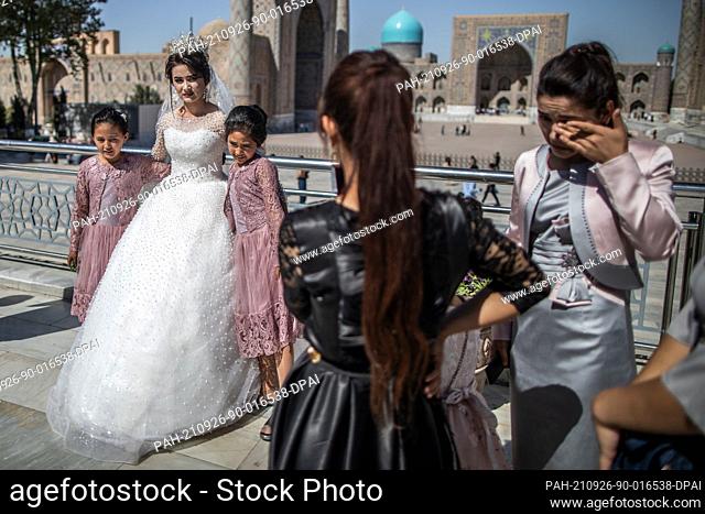 26 September 2021, Uzbekistan, Samarkand: An Uzbek bride has wedding pictures taken at the historical landmark of Registan in Samarkand