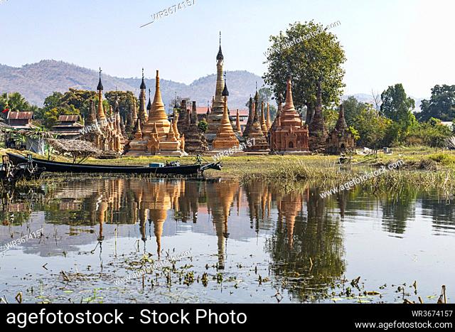 Myanmar, Shan State, Samkar, Stupas of Taw Mwe Khaung Pagoda reflecting in adjacent lake
