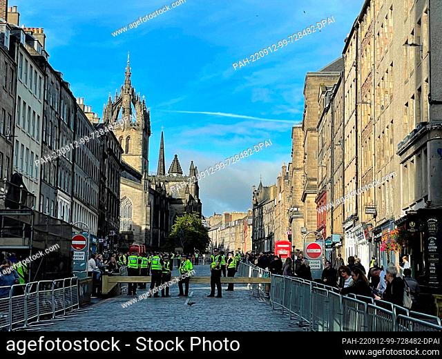 12 September 2022, Great Britain, Edinburgh: Police officers secure the Royal Mile, the road leading to St. Giles Cathedral visible in the background